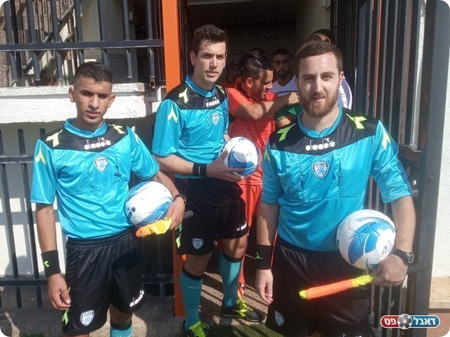 צוות השיפוט ושחקני כפר שלם והרצליה לפני העלייה למגרש (שלומי והבה)